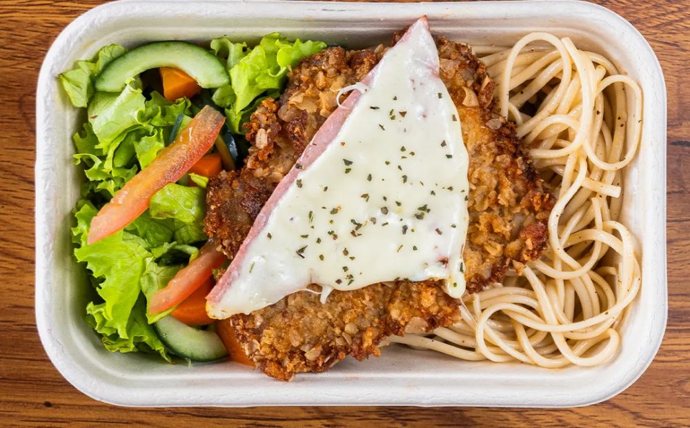 Milanesa napolitana con espagueti y ensalada en el empaque de Manzana Verde